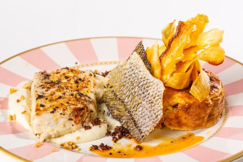 Texturas de Robalo e Macaxeira, do chef Leo Llopiz - Filé de Robalo em espuma de macaxeira, acompanha suflê de macaxeira e linguiça, pele crocante de robalo, chips de macaxeira e praliné de castanhas de caju - Foto: Divulgação
