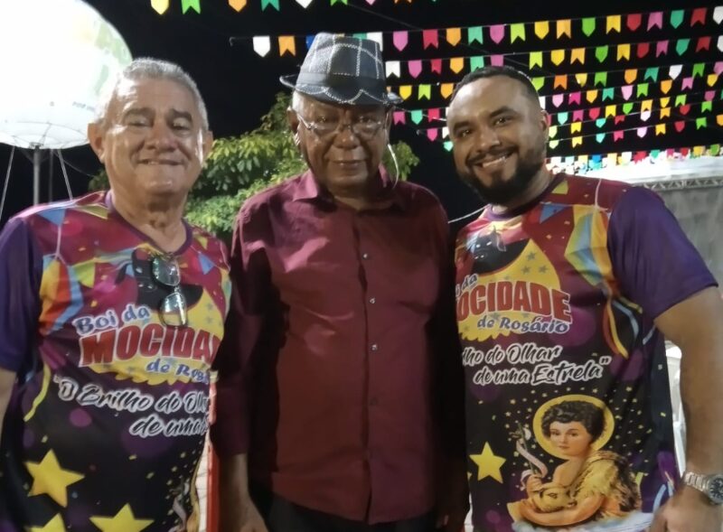 Ladeado por Hamilton Misteira e Luzian Filho, respectivamente, dirigente e cantador do Boi da Mocidade de Rosário, Herbert de Jesus Santos, descendente de criadores, presta apoio à festa – Foto: Antônio Carlos Tote 