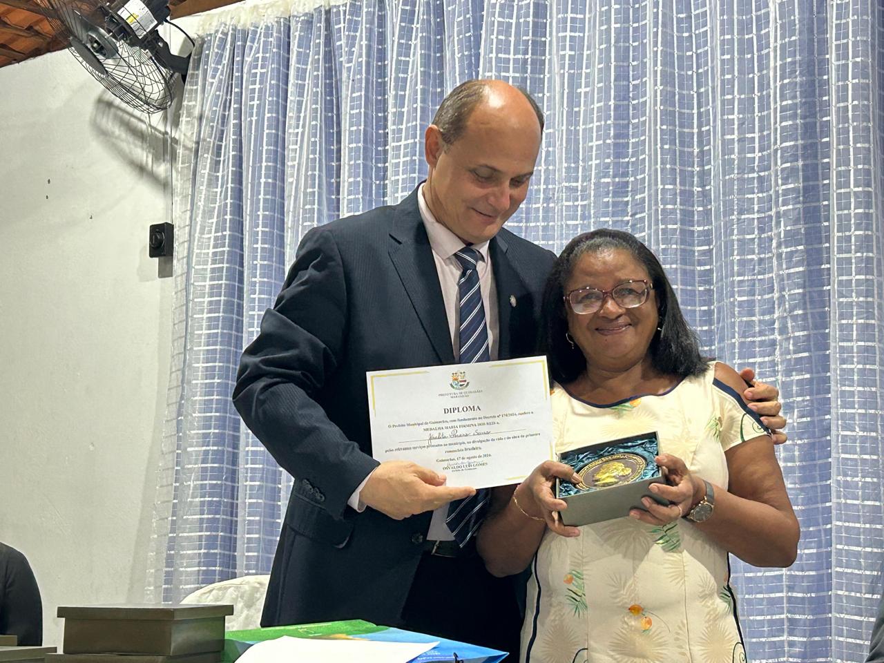 O presidente da FALMA, César Brito, entrega a medalha e o diploma à professora e atriz Joselita Pereira Souza – Foto: Iago Azevedo