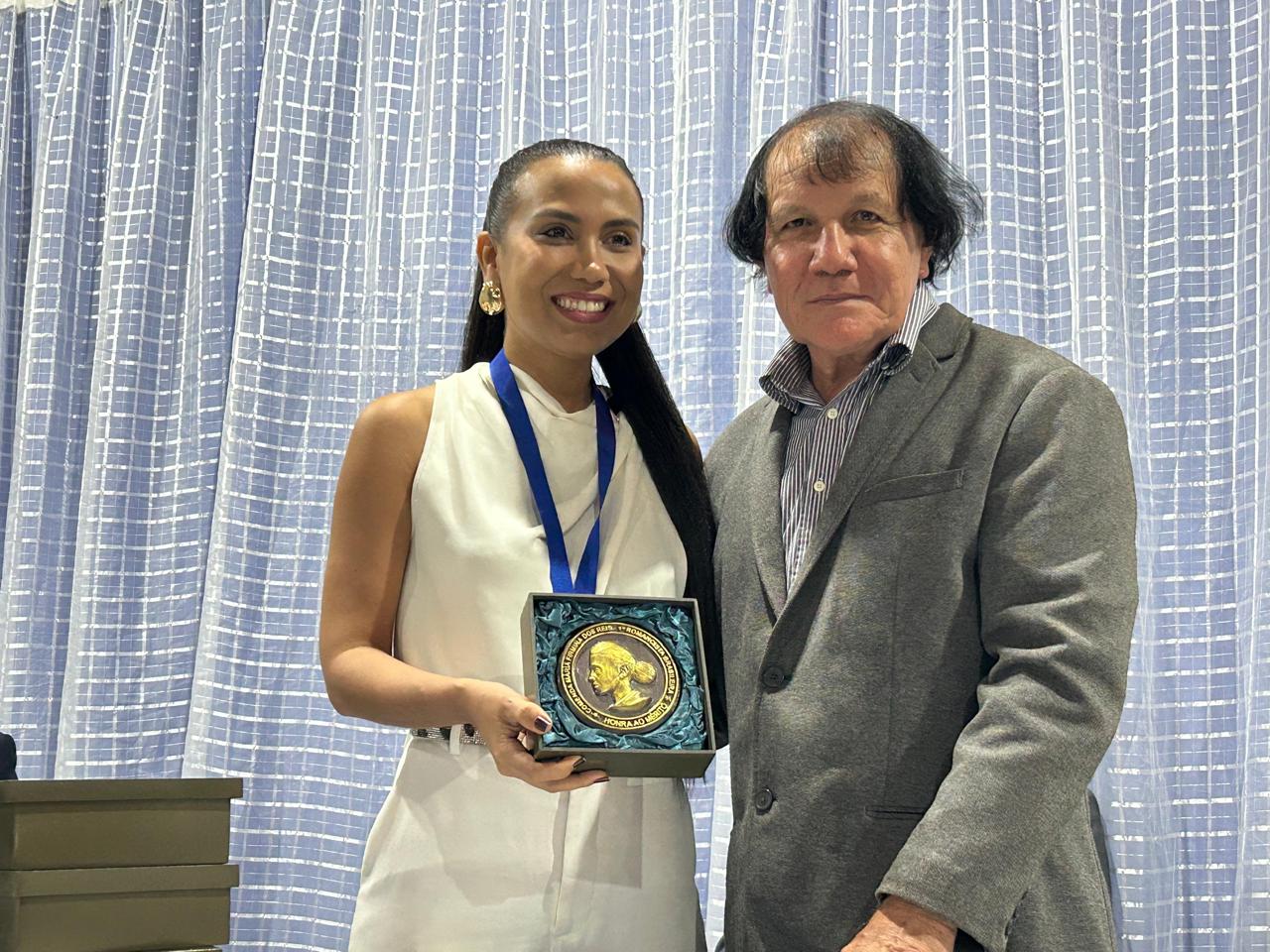 A escritora Anita Machado Gomes, diretora executiva do Instituto Da Cor ao Caso, recebe a medalha e o diploma das mãos do escritor Ewerton Neto, membro da AML – Foto: Iago Azevedo